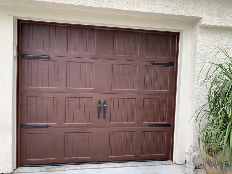 A single dark carriage-style garage door with decorative hardware, newly fitted