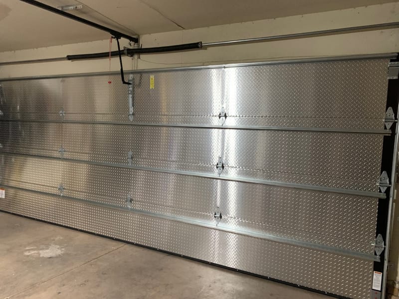 Interior view of a garage door showing the spring, shaft and opener rail